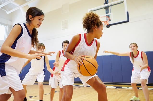 Mädchen spielen Basketball